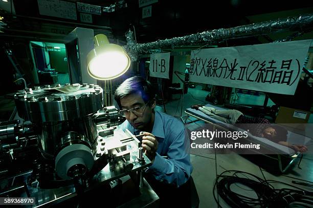 Physicist Ryuhei Sugahara adjusts a vacuum chamber, part of an apparatus which uses soft x-rays to study atomic crystal structure. Sugahara works the...
