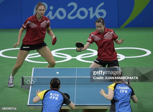 Austria's Sofia Polcanova watches Austria's Li Qiangbing hit a shot in the women's team quarter-final table tennis match against Japan's Mima Ito and...