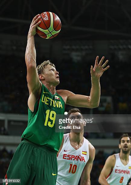 Mindaugas Kuzminskas of Lithuania goes to the basket against Victor Claver and Jose Calderon of Spain during the Men's Preliminary Round Group B...