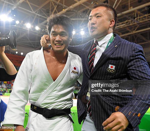 Ryunosuke Haga of Japan celebrates winning the bronze medal with his coach Keiji Suzuki after beating Artem Bloshenko of Ukraine during the men's...