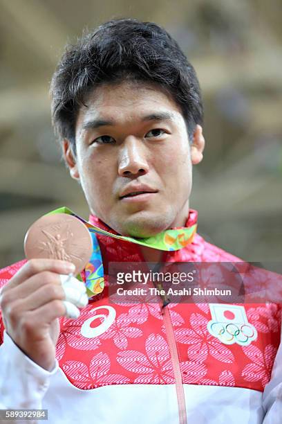 Bronze medalist Ryunosuke Haga of Japan poses for photographs after the medal ceremony for the men's -100kg on Day 6 of the 2016 Rio Olympics at...