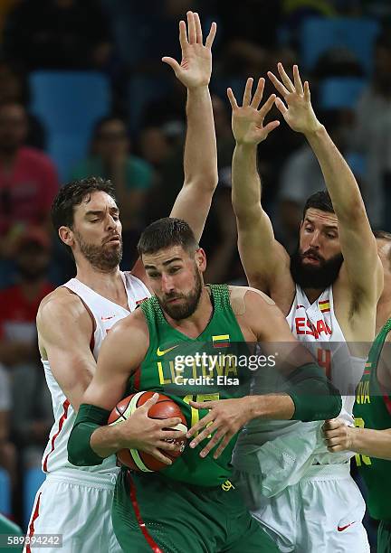 Jonas Valanciunas of Lithuania handles the ball under pressure from Pau Gasol and Nikola Mirotic of Spain during the Men's Preliminary Round Group B...