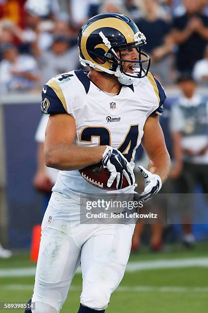 Chase Reynolds of the Los Angeles Rams runs the ball into the end zone at the Los Angeles Memorial Coliseum during a preseason game against the...