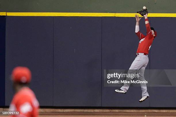 Tyler Holt of the Cincinnati Reds makes an outstanding catch in centerfield to retire Chris Carter of the Milwaukee Brewers during the eighth inning...