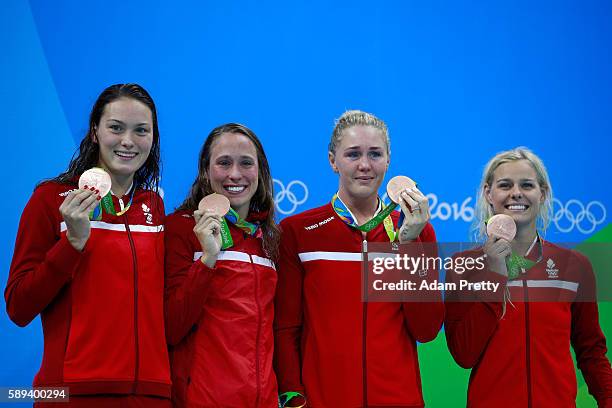 Bronze medalists Kylie Masse, Rachel Nicol, Penny Oleksiak and Chantal Van Landeghem of Canada celebrate on the podium during the medal ceremony for...