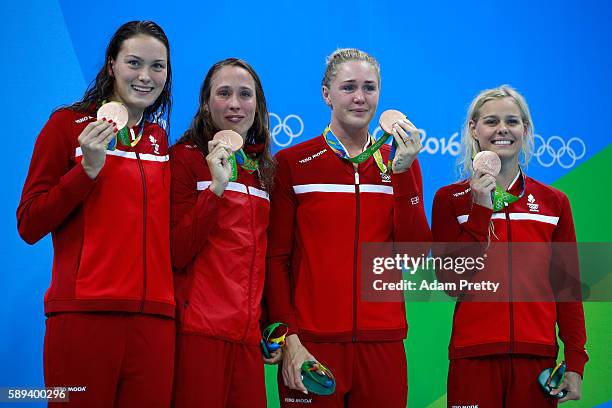 Bronze medalists Kylie Masse, Rachel Nicol, Penny Oleksiak and Chantal Van Landeghem of Canada celebrate on the podium during the medal ceremony for...