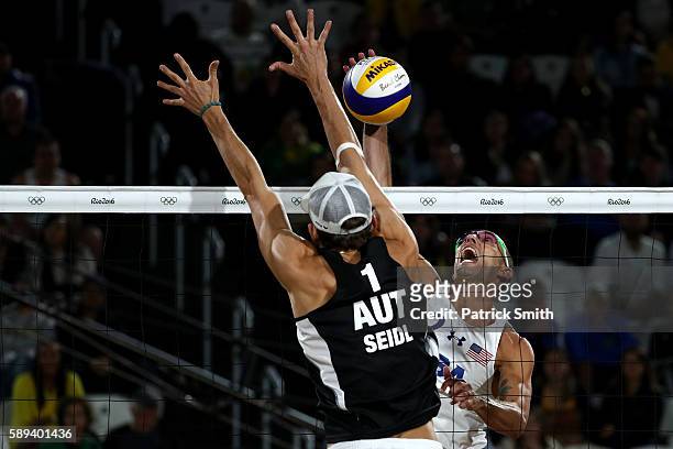 Nicholas Lucena of United States spikes the ball against Robin Seidl of Austria during a Men's Round of 16 match between the United States and...