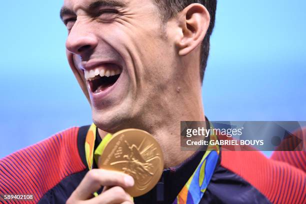 S Michael Phelps poses with his gold medal during the podium ceremony of the Men's swimming 4 x 100m Medley Relay Final at the Rio 2016 Olympic Games...