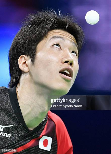 Japan's Jun Mizutani competes against Jakub Dyjas of Poland in a table tennis men's team event first-round match at the Rio de Janeiro Olympics on...