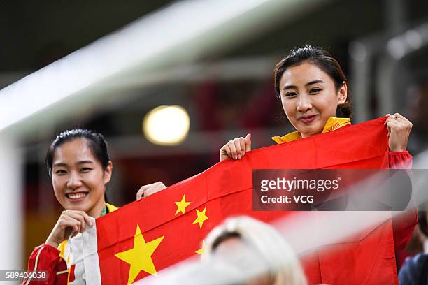 Rio de Janeiro, Brazil Chinese trampoline gymnasts Li Dan and He Wenna pose with Chinese National flag when watching the Men's Trampoline Final on...