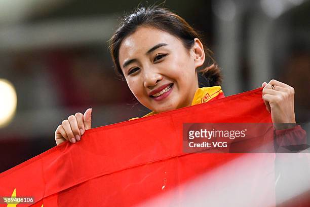 Rio de Janeiro, Brazil Chinese trampoline gymnast He Wenna poses with Chinese National flag when watching the Men's Trampoline Final on Day 8 of the...