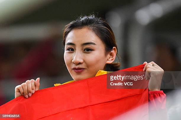 Rio de Janeiro, Brazil Chinese trampoline gymnast He Wenna poses with Chinese National flag when watching the Men's Trampoline Final on Day 8 of the...