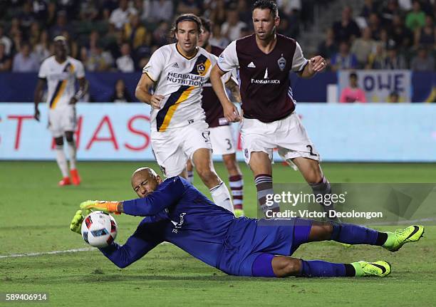 Goalkeeper Tim Howard of Colorado Rapids makes a save as Alan Gordon of Los Angeles Galaxy and Bobby Burling of Colorado Rapids look for the rebound...