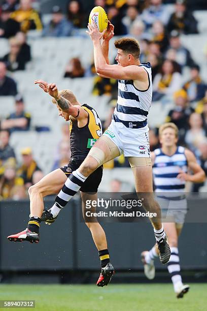 Zac Smith of the Cats marks the ball against Brandon Ellis of the Tigers during the round 21 AFL match between the Richmond Tigers and the Geelong...