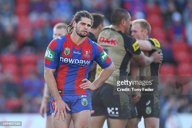Jake Mamo of the Knights looks dejected as the Panthers celebrate a try during the round 23 NRL match between the Newcastle Knights and the Penrith...