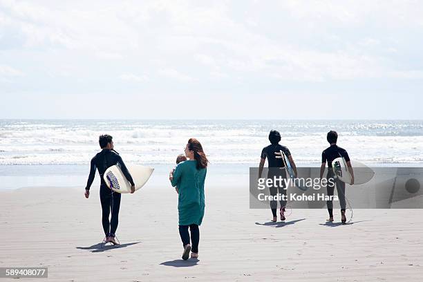 surfers, mother and baby walking on the beach - beach holding surfboards stock pictures, royalty-free photos & images