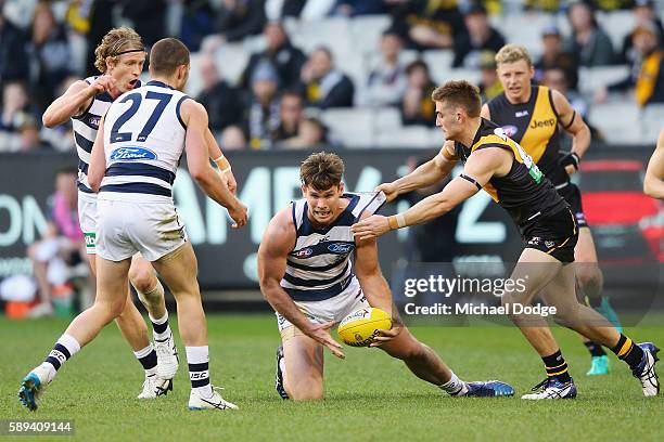 Anthony Miles of the Tigers tackles Tom Hawkins of the Cats during the round 21 AFL match between the Richmond Tigers and the Geelong Cats at...