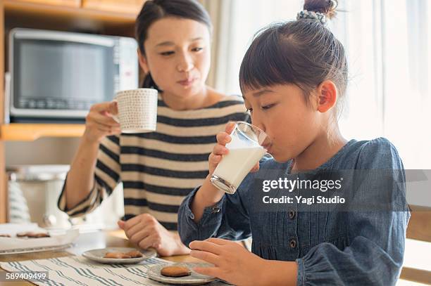 girl is drinking milk with mother - milk family stockfoto's en -beelden