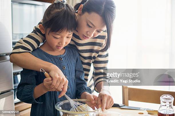 mother and daughter making  cookies together - cooking ストックフォトと画像