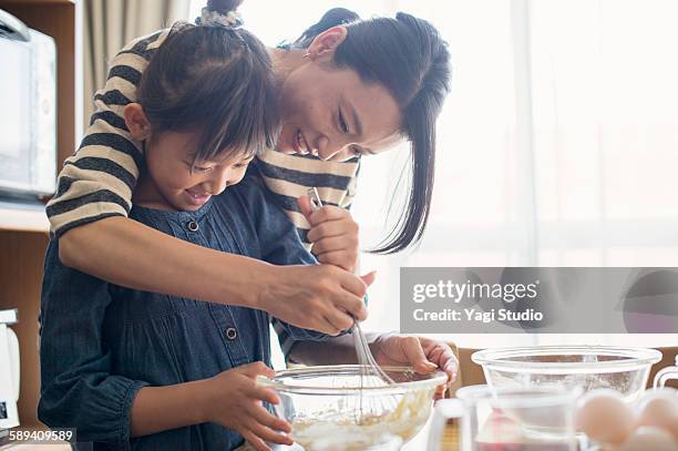 mother and daughter making  cookies together - baking fotografías e imágenes de stock