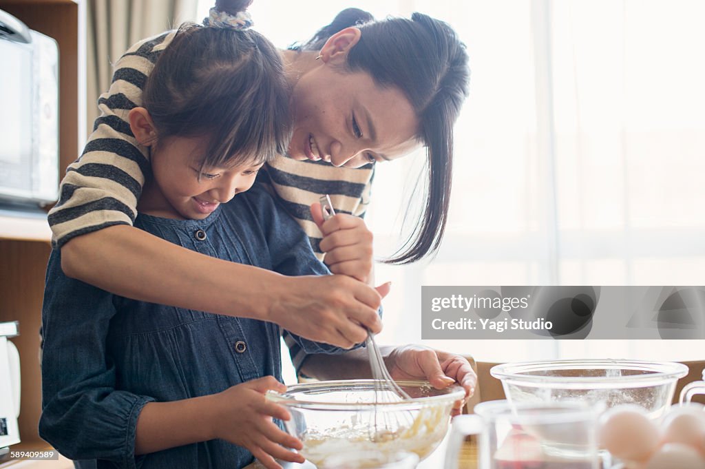 Mother and daughter making cookies together