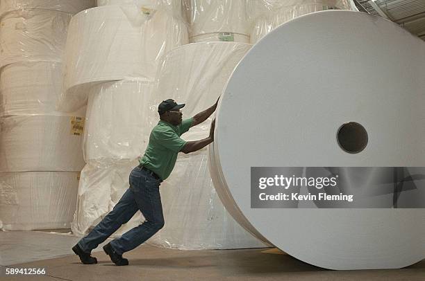 factory worker pushing roll of paper - role stock-fotos und bilder