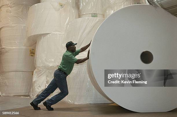 factory worker pushing roll of paper - p&g stock pictures, royalty-free photos & images