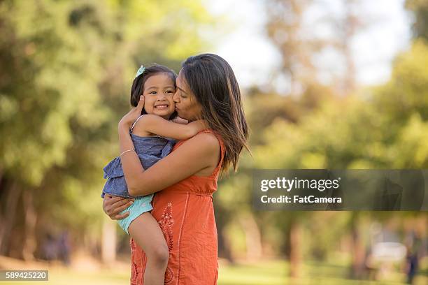 étnico joven madre que enaltece su niño niña al aire libre - filipino fotografías e imágenes de stock