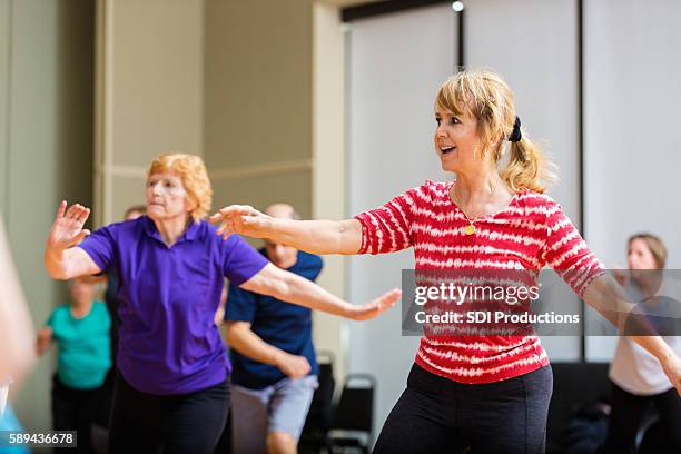 active seniors take dance lessons at senior center - line dancing stock pictures, royalty-free photos & images