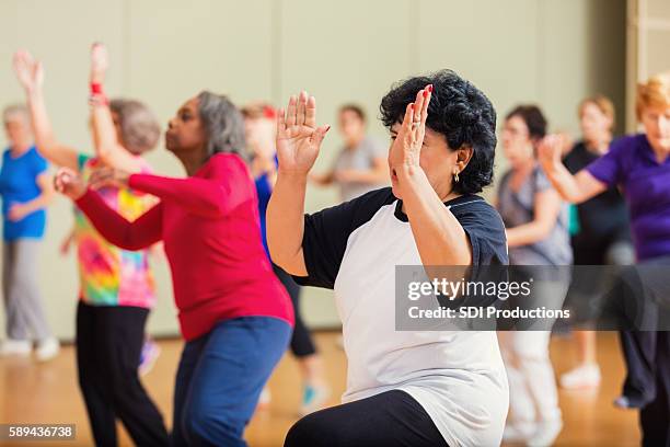 large group of people take dance lessons - active seniors dancing stock pictures, royalty-free photos & images