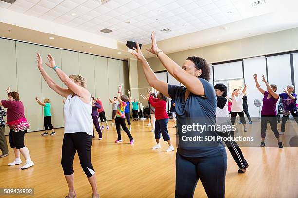 group of people reaching up in dance class - line dancing stock pictures, royalty-free photos & images