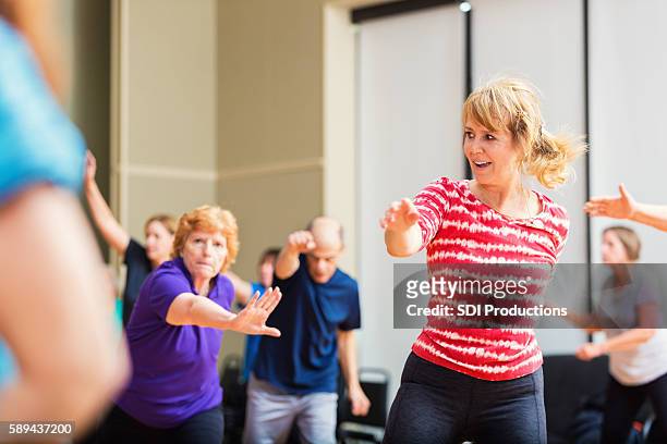 large group of people taking dancing fitness class - line dancing stock pictures, royalty-free photos & images