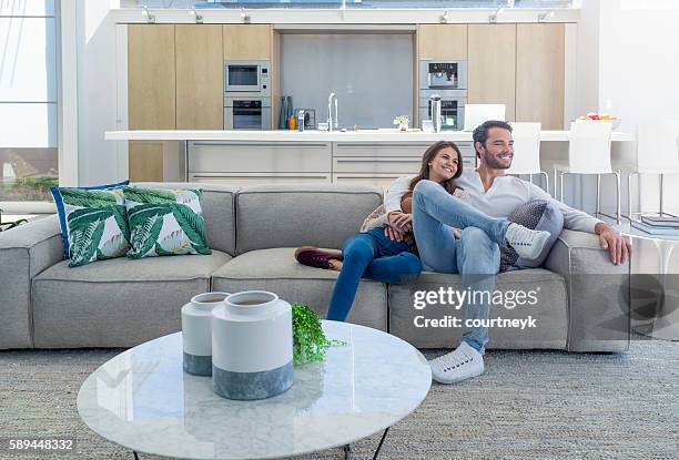 pareja sentada en una moderna casa de planta abierta. - beautiful wife pics fotografías e imágenes de stock