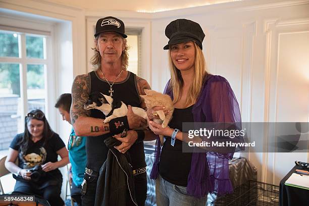 Duff McKagan of Guns and Roses and wife Susan Holmes-McKagan hold Motley Zoo rescue animals backstage during the Summer Camp music Festival at...