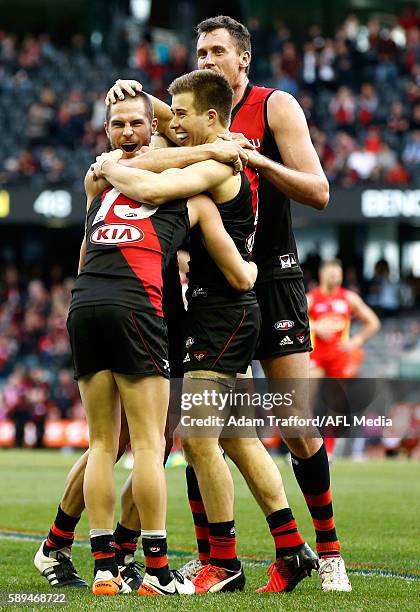 Acting captain Zach Merrett of the Bombers celebrates on the final siren with David Zaharakis and Matthew Leuenberger of the Bombers during the 2016...