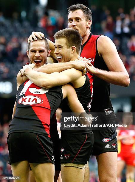 Acting captain Zach Merrett of the Bombers celebrates on the final siren with David Zaharakis and Matthew Leuenberger of the Bombers during the 2016...