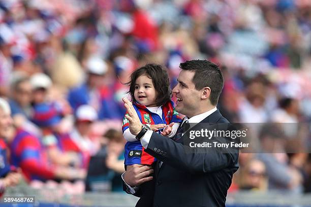 James McManus of the Knights with daughter Emelyn say farewell to supporters after retiring from football the round 23 NRL match between the...