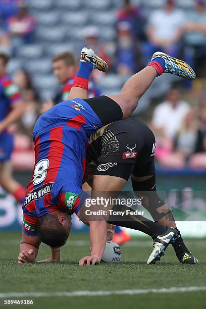 Sam Mataora of the Knights is upended by a Panthers player during the round 23 NRL match between the Newcastle Knights and the Penrith Panthers at...
