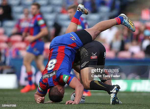 Sam Mataora of the Knights is upended by a Panthers player during the round 23 NRL match between the Newcastle Knights and the Penrith Panthers at...