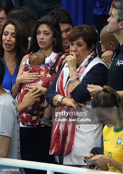 Nicole Johnson, fiancee of Michael Phelps - holding their baby son Boomer Phelps -, and Debbie Phelps, Michael's mother cheer for him and his...