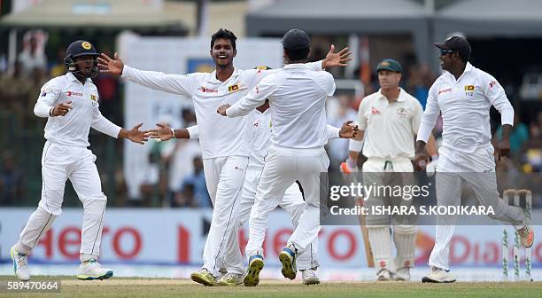 Sri Lanka cricketer Dhananjaya de Silva celebrates with teammates after he dismissed Australian cricketer David Warner during the second day of the...