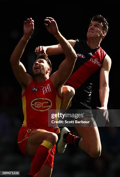 Matthew Leuenberger of the Bombers and Keegan Brooksby of the Suns compete for the ball during the round 21 AFL match between the Essendon Bombers...