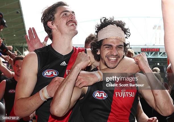 Jake Long, Joe Daniher and the Bombers celebrate as they walk to the rooms after winning the round 21 AFL match between the Essendon Bombers and the...