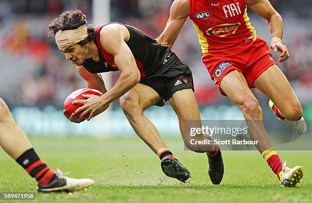Jake Long of the Bombers runs with the ball during the round 21 AFL match between the Essendon Bombers and the Gold Coast Suns at Etihad Stadium on...