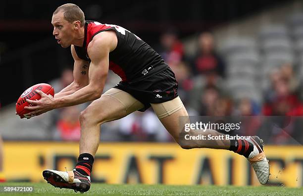 James Kelly of the Bombers runs with the ball during the round 21 AFL match between the Essendon Bombers and the Gold Coast Suns at Etihad Stadium on...