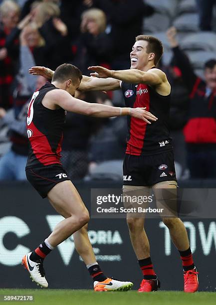 Zach Merrett and Orazio Fantasia of the Bombers celebrate winning at the final siren the round 21 AFL match between the Essendon Bombers and the Gold...