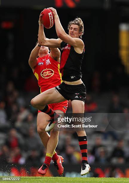 Joe Daniher of the Bombers and Steven May of the Suns compete for the ball during the round 21 AFL match between the Essendon Bombers and the Gold...