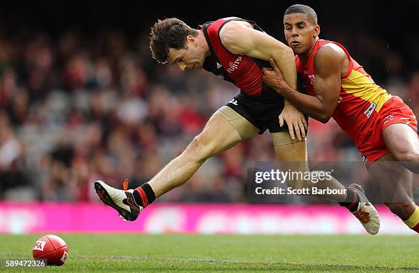 Jonathan Simpkin of the Bombers is tackled by Touk Miller of the Suns during the round 21 AFL match between the Essendon Bombers and the Gold Coast...