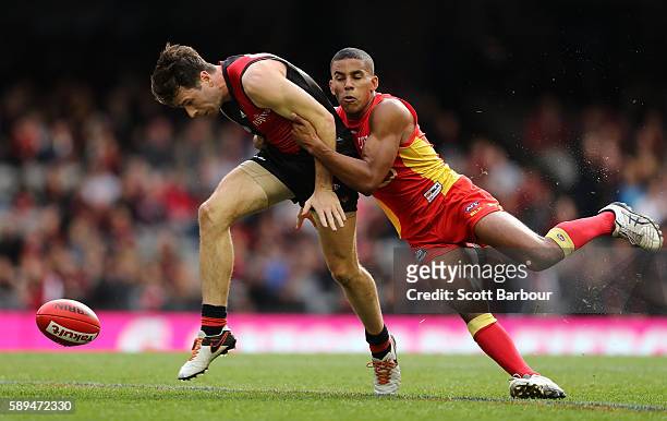 Jonathan Simpkin of the Bombers is tackled by Touk Miller of the Suns during the round 21 AFL match between the Essendon Bombers and the Gold Coast...