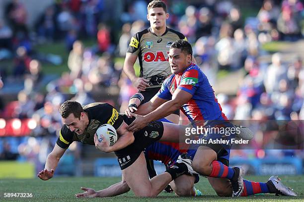 Isaah Yeo of the Panthers is tackled by the Knights defence during the round 23 NRL match between the Newcastle Knights and the Penrith Panthers at...